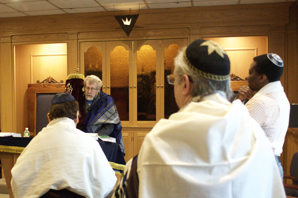 Rabbi Emeritus Ira Korinow holding the Torah during Shabbat services.